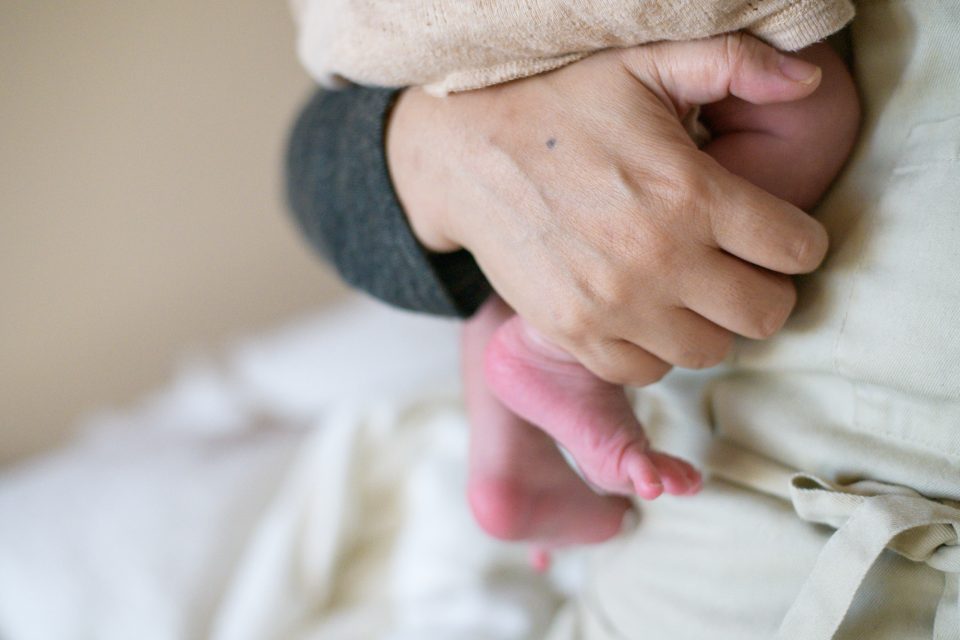 助産師さんの手と赤ちゃんの足
